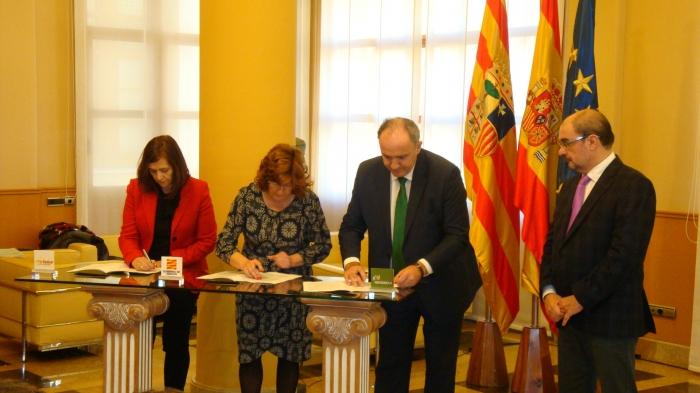 Desde la izquierda, Carmen Sánchez, Mª Victoria Broto y Eduardo Insunza firman el convenio en presencia de Javier Lambán.